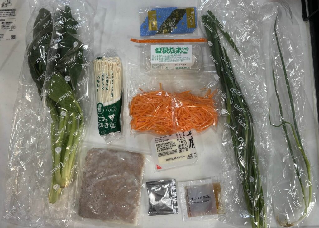 kit oisixビビンバとスープの中身
小松菜、エリンギ、カットされたニンジン、豆腐、そぼろ、ニラ、小ねぎが写っている。